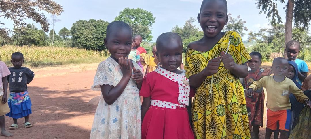 Drei lachende Mädchen vor dem Maisfeld in Uganda