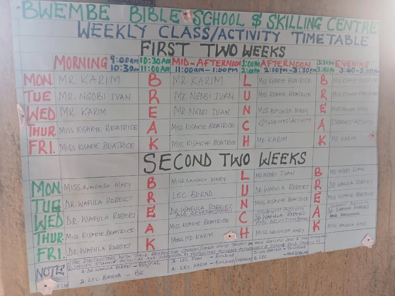 Der handgeschriebene Wochenstundenplan der Bwembe Bible School and Skilling Centre an der Schulwand