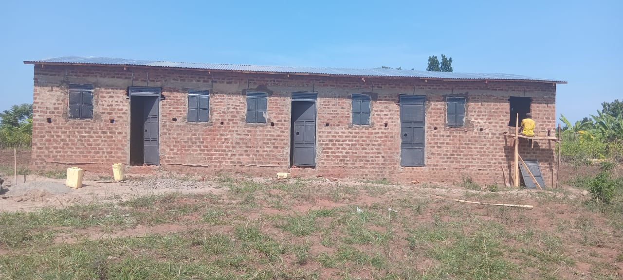 Das Lehrerhaus mit neu eingebauten Türen und Fenstern, Handwerker auf einem Holzgerüst